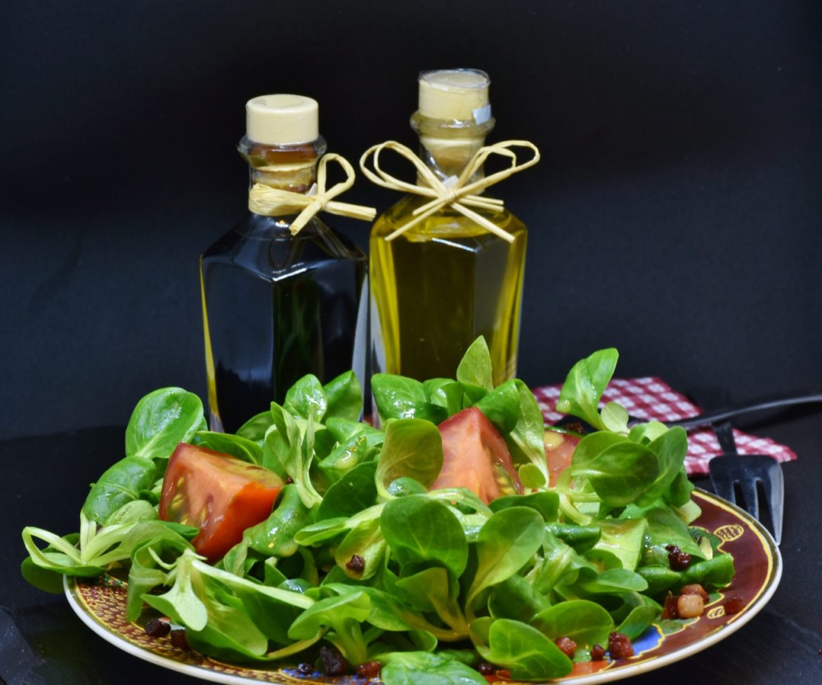 A Plate of Salad and Two Bottles of Oil