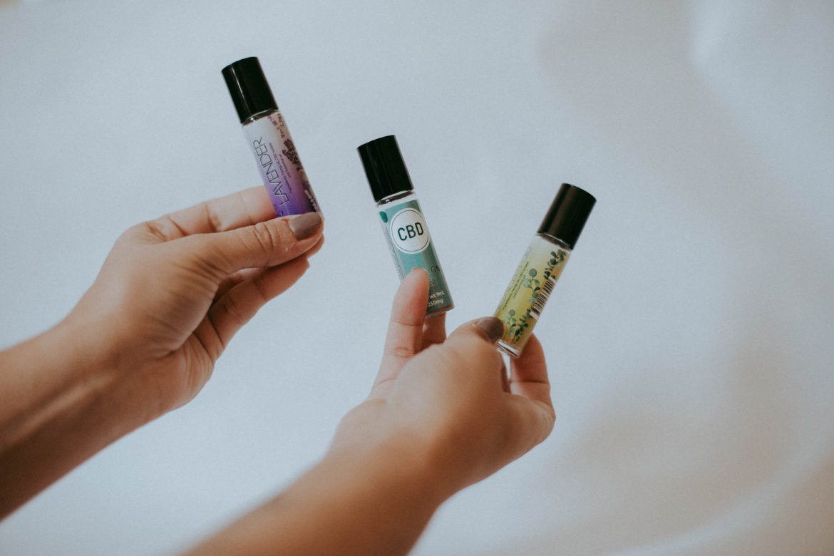 Person Holding Bottles of Essential Oils