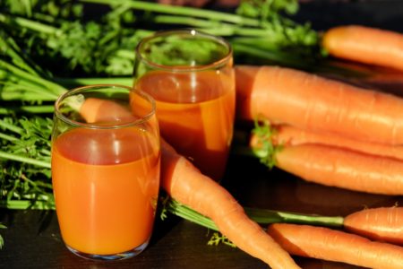 Whole Carrots and Glasses of Carrot Juices