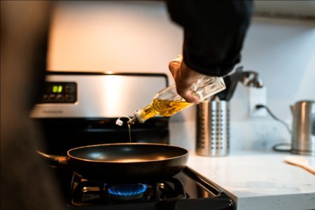A Person Pouring Oil in a Wok